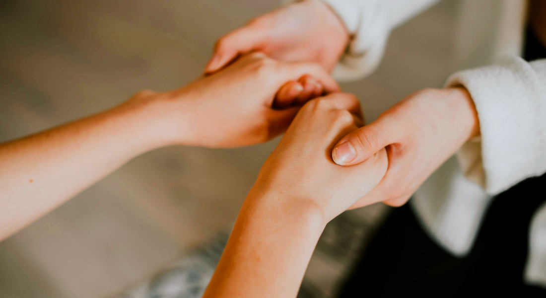 two pairs of hands holding each other