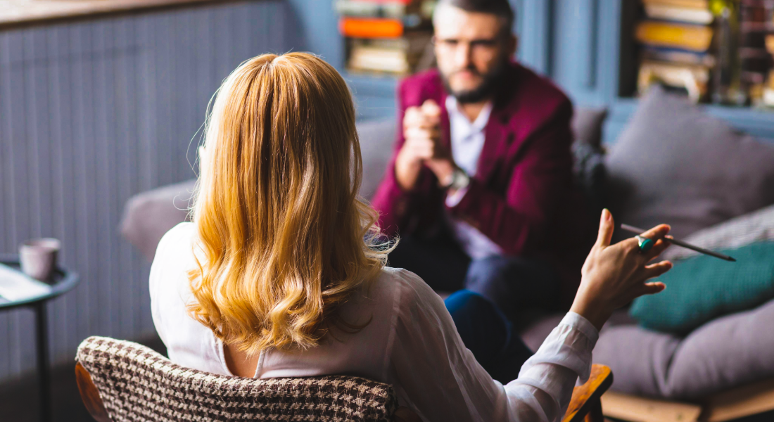 man and woman talking in a therapist office