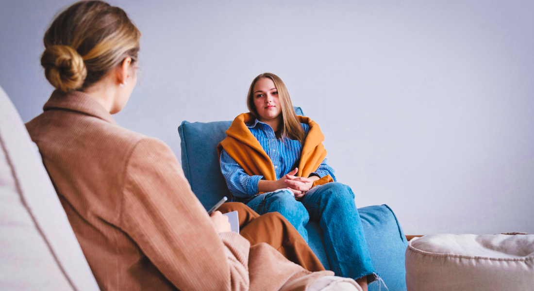 two women sitting in chairs talking