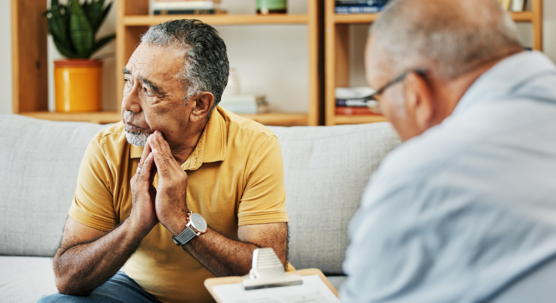 man on a couch talking to a man with a clipboard