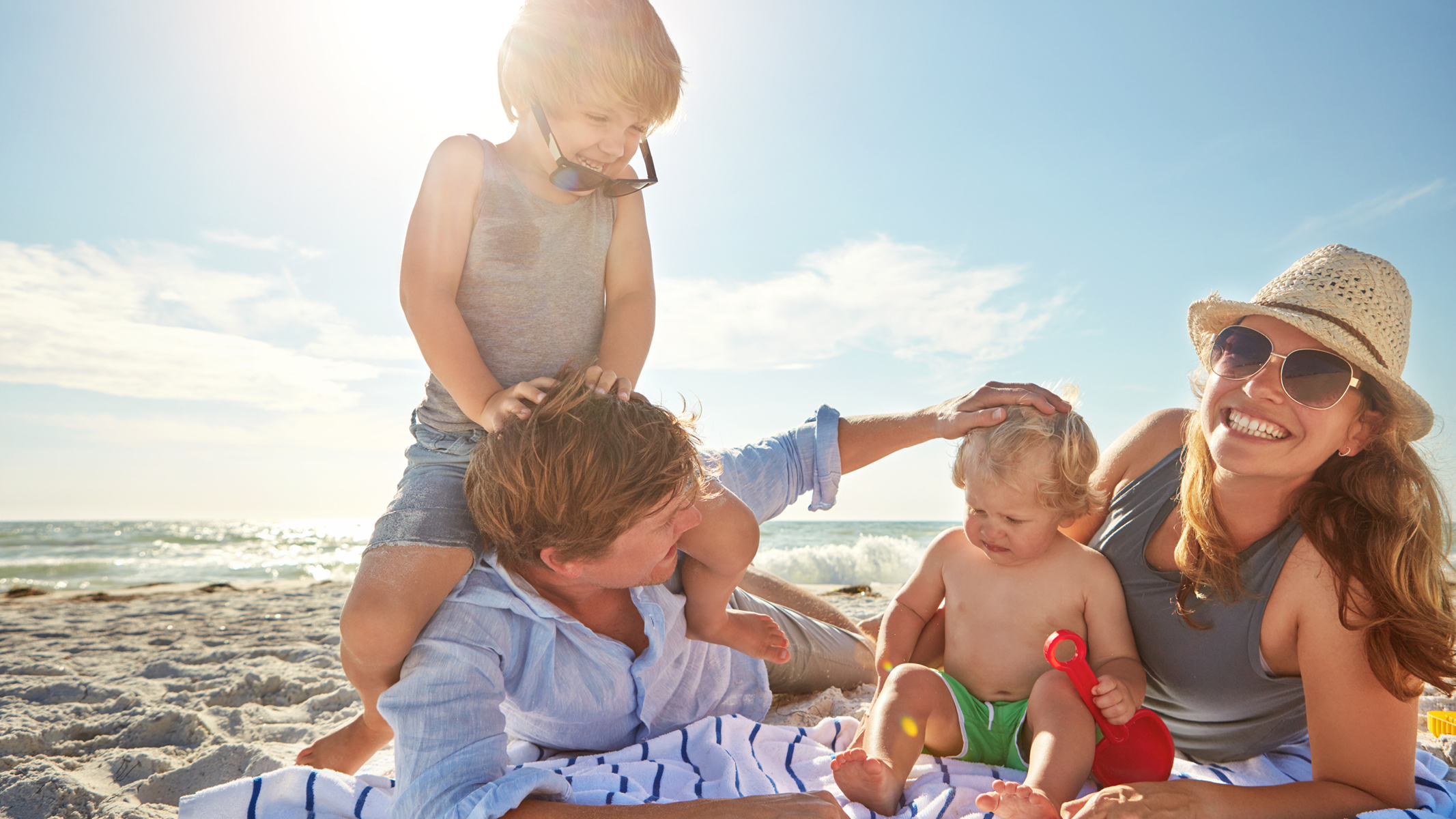 Man, woman, and two kids playing on the beach.